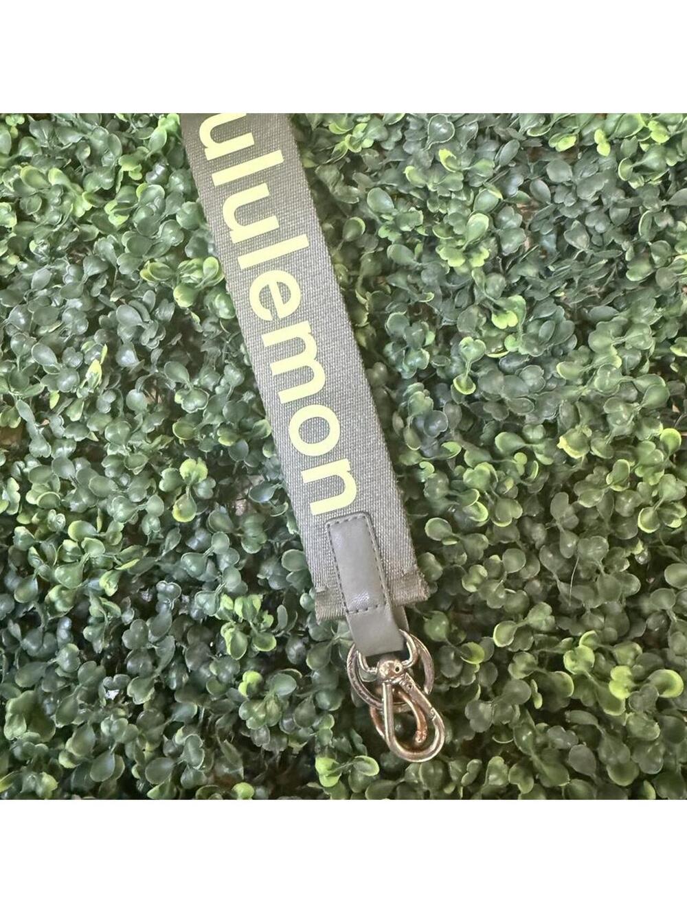 Lululemon Never Lost Keychain featuring a dark gray/olive woven wrist strap.